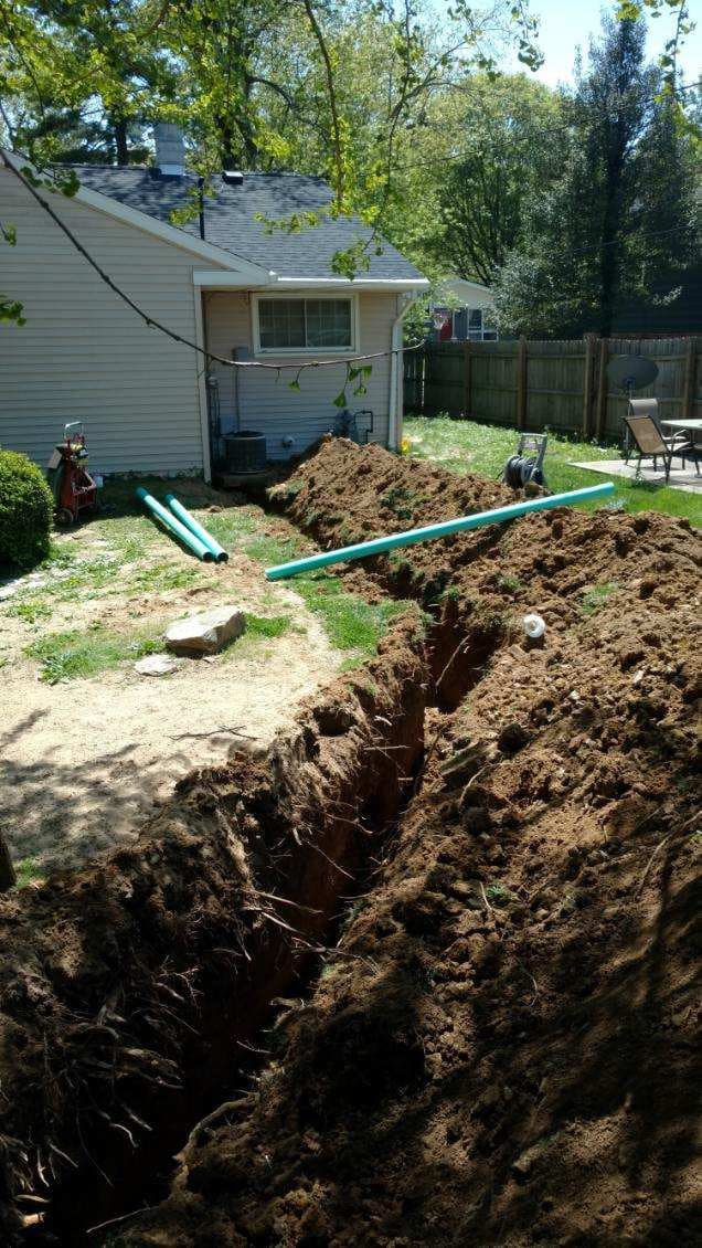 Plumber in Evansville, IN — sewer excavation with green pipe staged beside a backyard trench