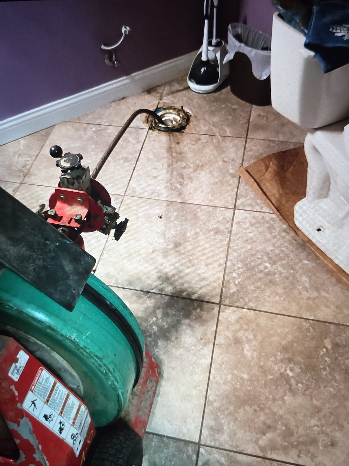 Plumber in Evansville, IN — drain cable machine at an open toilet flange