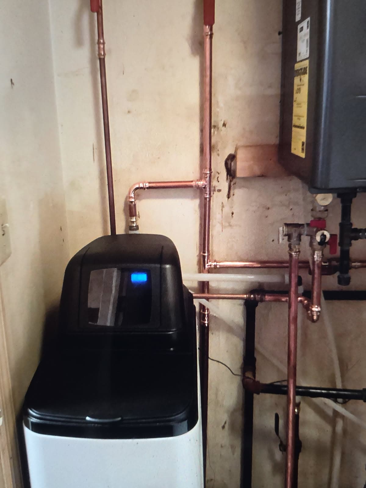 Plumber in Evansville, IN — water softener piped in copper beside a tankless water heater